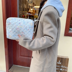 Trousse de toilette matelassée avec motifs animés portée par un mannequin en extérieur