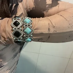 Détail de bracelets extensibles bohèmes avec pierres géométriques noires et turquoise