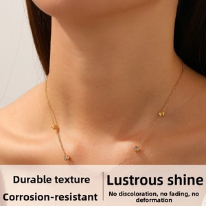 Dettaglio di una delicata collana a rosa placcata oro con ciondoli in zircone e catena