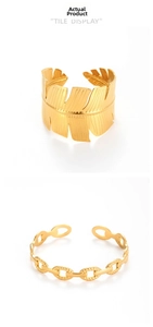 Detail of gold-plated leaf texture cuff and oval link chain bracelet set on white background