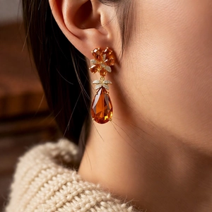 Détail de boucles d'oreilles vintage goutte ambre avec grappe de zircon sur modèle