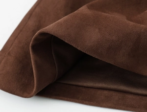 Vue détaillée montrant la texture douce et les plis du tissu en daim marron
