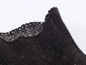 Detail of black knit fabric showing premium texture and wavy edge craftsmanship