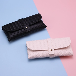 Detail of woven faux leather glasses cases with snap button and cross-braided texture