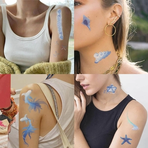 Detail of ocean-themed temporary tattoos with blue sea waves and shells on skin