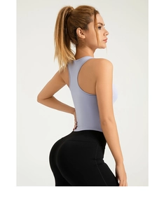 Dettaglio del top da yoga viola chiaro con taglio vogatore e tessuto elastico