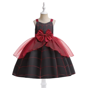 Detail of girls pumpkin witch dress showing spider web pattern and red bow decoration