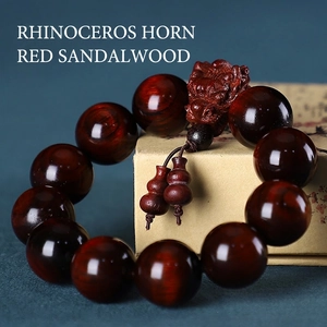Gros plan de perles en bois de santal rouge avec sculpture d'animal et détail de pompon