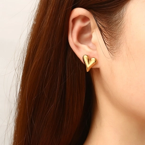 Boucles d'oreilles cœur dorées 18K sur modèle au design bombé 3D poli brillant