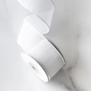 Detailed view of white faux linen ribbon with mesh texture for DIY Christmas bows