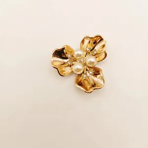 Elegant gold flower brooch accessory featuring four white pearls and sparkly rhinestones