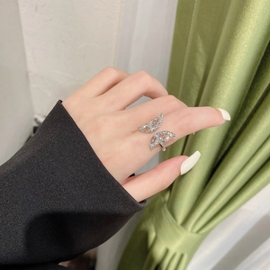 Detailed close-up of a silver bow ring featuring pavé-set sparkling zircons on a finger