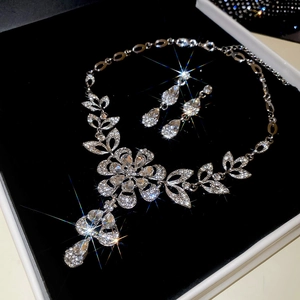Close-up of sparkling crystal flower necklace and teardrop earrings in a velvet gift box