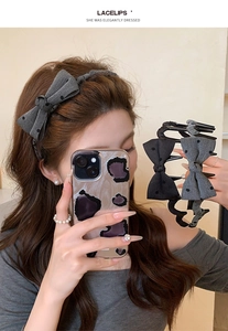 Fashionable polka dot bow headband shown on model to enhance hairstyles and head shape