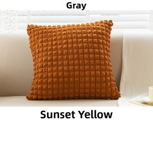 Detail of sunset yellow waffle texture pillow case on a sofa under soft sunlight