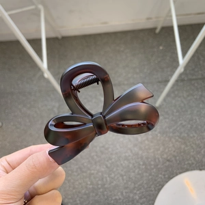 Close-up of tortoise shell bow hair claw clip with durable metal spring detail