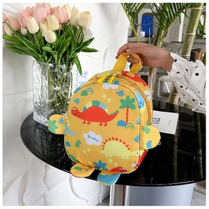 Close-up of yellow dinosaur toddler backpack with cartoon prints and handle detail