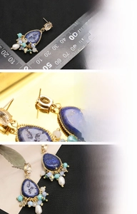 Detail of bohemian drop earrings with teardrop semi-precious stone and 18K gold plating