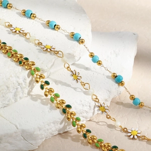Minimalist 18K gold plated beaded bracelet with blue daisy and green leaf charms