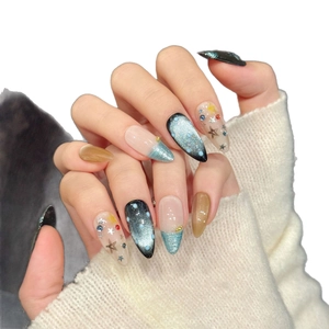 Cat eye press-on nails in deep blue and amber glitter with silver star accents