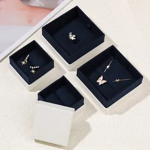 Elegant white jewelry box set with deep blue velvet lining for rings and necklaces