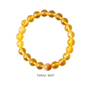 Macro detail of 8-10mm translucent citrine crystal beads on a stretch bracelet