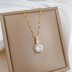 Vue détaillée du collier doré étincelant avec zircon sur un coffret à bijoux beige