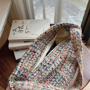 Detail of colorful tweed knit bag with double magnetic clasps and beige lining texture