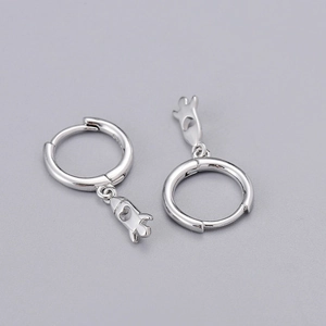 Macro detail of silver S925 sterling silver hoop earrings with hollow rocket pendants
