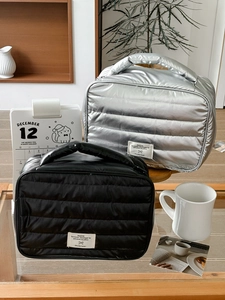 Minimalist quilted makeup bags in silver and black with top handles for travel use