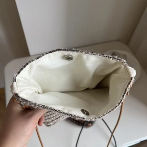 Detail of woven crossbody bag with magnetic buckle closure and canvas lining