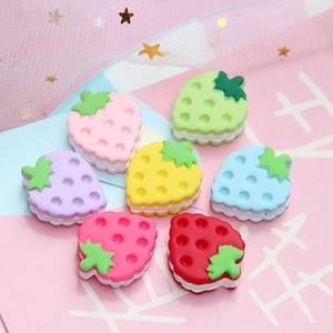 Detailed view of colorful resin strawberry-shaped charms for DIY cream glue crafts