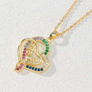 Macro shot of gold double heart pendant with MAMA engraving and colorful zircons