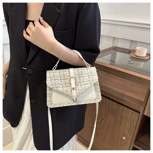 Detailed view of tweed crossbody bag with gold metallic thread and leather flap