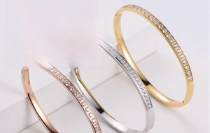 Detailed view of three-color minimalist bangles with CNC cubic zirconia inlay on white stand