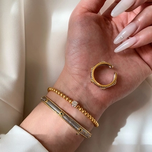 Vintage style gold and silver jewelry set featuring embossed ring and beaded gem bracelet