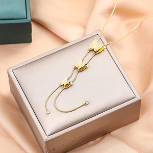 Collier élégant avec pendentif papillon plaqué or 18k sur fond de soie champagne