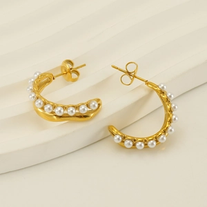 Elegant 18K gold-plated C-shape earrings with white pearls on a textured background