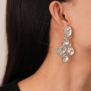 Macro detail of luxury silver drop earrings with shimmering crystals on a female model
