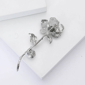 Detaillierte Rückansicht der silbernen Rosenbrosche mit Metallstruktur und Verschlussnadel