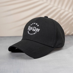 Black cotton baseball cap with white Rich Day embroidery and star pattern on curved brim