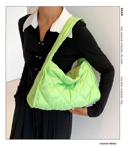 Detail of neon green quilted nylon puffer shoulder bag with stylish typography