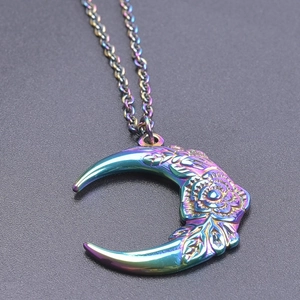 Detailed view of rainbow stainless steel crescent moon pendant with floral engraving
