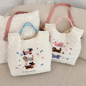 Close-up of quilted heart patterns and cute cartoon embroidery on soft shoulder bags
