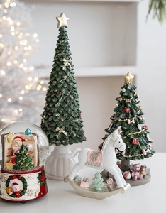 Detail of Christmas resin rocking horse and snowy trees with cozy festive bokeh lighting