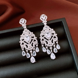 Detailed close-up of silver tassel earrings with pear-shaped stones in jewelry box