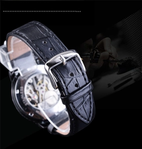 Detail of vintage mechanical watch skeleton back with leather strap and steel buckle