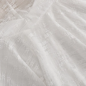 Gros plan sur un tissu en dentelle blanche avec crochet floral et textures verticales