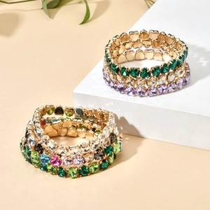 Detail of stacked multi-layer elastic bracelets with colorful heart-shaped crystals