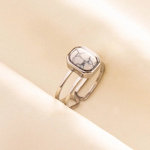 Detail of silver stainless steel ring with rectangular white howlite stone on champagne satin